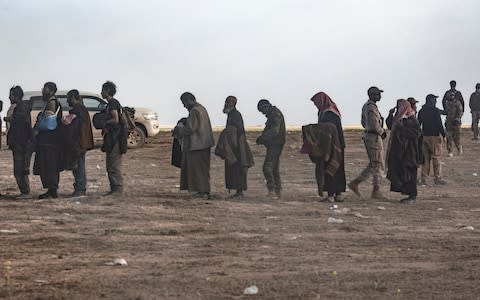 Isil fighters who surrendered to the Syrian Democratic Forces are processed on a hilltop outside Baghuz - Credit: Sam Tarling for The Telegraph
