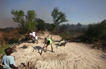 FILE PHOTO: Residents of Khayelitsha township erect shacks during an illegal land occupation near Cape Town, South Africa. April 7, 2015. REUTERS/Mike Hutchings/File Photo