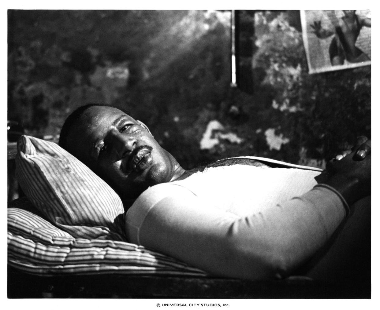Frank McRae laying in bed in a scene from the film 'Paradise Alley', 1978. (Photo by Universal/Getty Images)