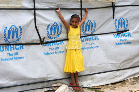 A Syrian refugee girl stands outside a tent as she poses at a refugee camp in Zahrani town, southern Lebanon June 13, 2018. REUTERS/Ali Hashisho