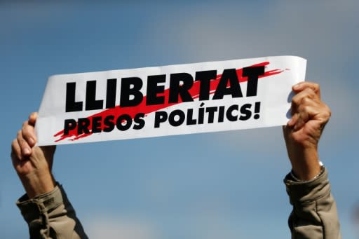 A man holds a placard reading 'Free political prisoners' during a protest called by Catalan pro-independence demonstrators