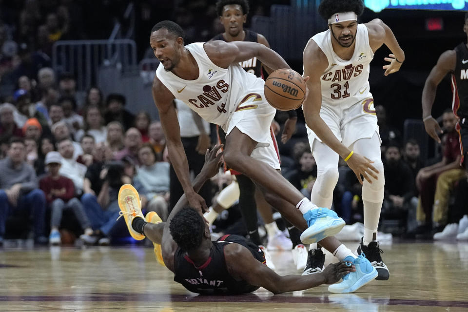 Cleveland Cavaliers forward Evan Mobley (4) collides with Miami Heat center Thomas Bryant, bottom, and is called for a foul during the first half of an NBA basketball game, Wednesday, Nov. 22, 2023, in Cleveland. (AP Photo/Sue Ogrocki)