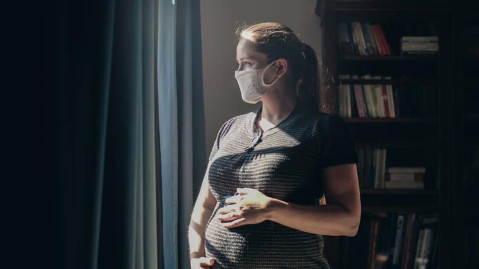 Una mujer embarazada con mascarilla