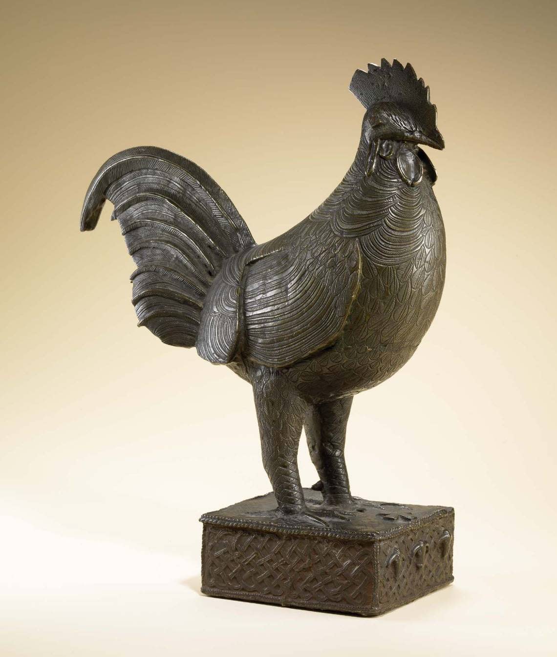 Rooster figure made by an Edo artist in the 18th century with three cows or ram heads on the front of its square base.