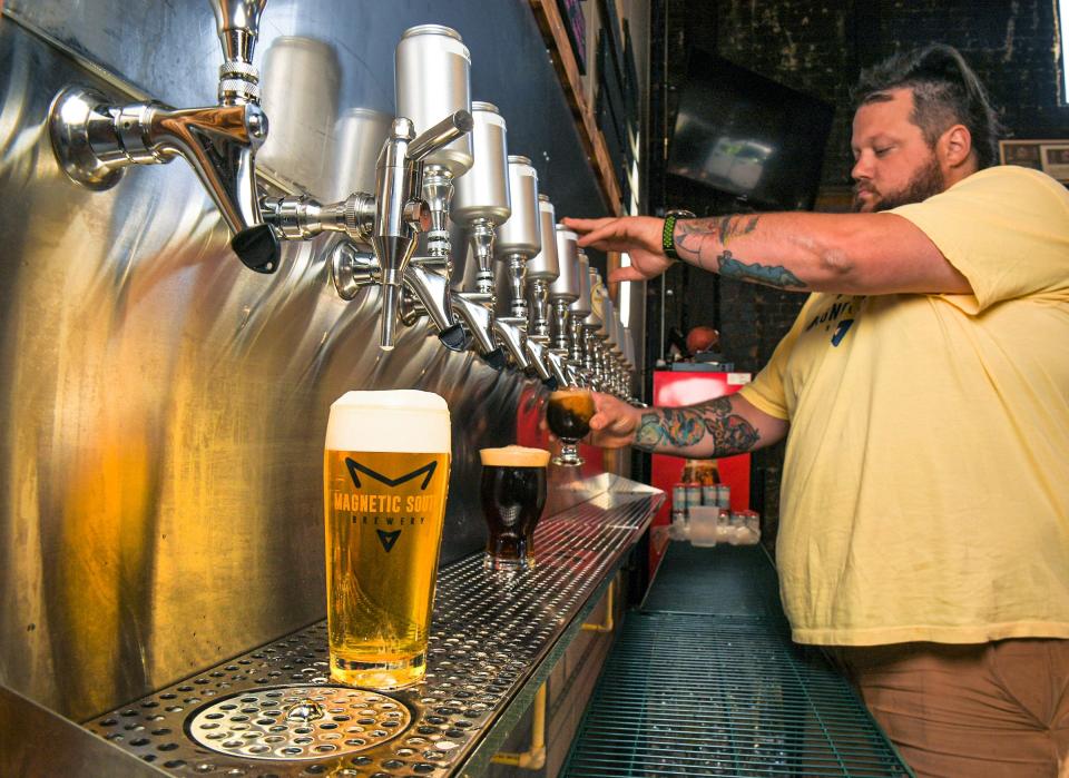 Adam "Cuzzin" Willier, head brewer, pours beer at Magnetic South Brewery in Anderson, S.C., October 2021.