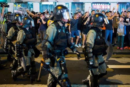 FILE PHOTO: Locals shout at riot police as they chase anti-government protesters down Nathan Road in Mong Kok in Hong Kong