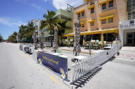 Empty outdoor seating for a restaurant and closed hotels are shown, Tuesday, Aug. 11, 2020, in Miami Beach, Florida's famed Ocean Drive on South Beach. Florida added 276 fatalities to its coronavirus death toll on Tuesday, a new state record. (AP Photo/Wilfredo Lee)