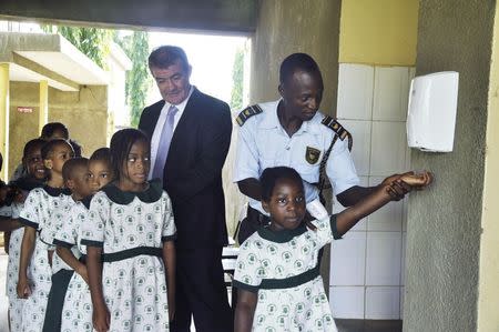 Pupils of Olumawu School are guided through the use of hand sanitizers, as school resumes in Abuja September 22, 2014. REUTERS/Stringer