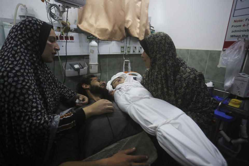 Una palestina muestra el cadáver de su nieta al padre de la beba luego de que murió a causa de un bombardeo israelí en la Franja de Gaza, el martes 19 de diciembre de 2023, en Rafah. (AP Foto/Hatem Ali)