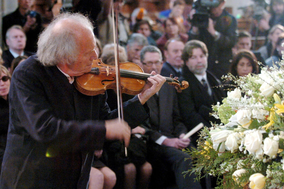 FILE - In this April 3 2004, Israeli violinist Ivry Gitlis, ambassador to the UNESCO, plays at the funeral ceremony of Oscar-winning British actor and play-writer, Sir Peter Ustinov, in the cathedral St. Pierre, in Geneva, Switzerland. Ivry Gitlis, an acclaimed violinist who played with famed conductors, rock stars and jazz bands around the world and worked to make classical music accessible to the masses, has died in Paris at 98. (Martial Trezzini/Pool Photo via AP, File)