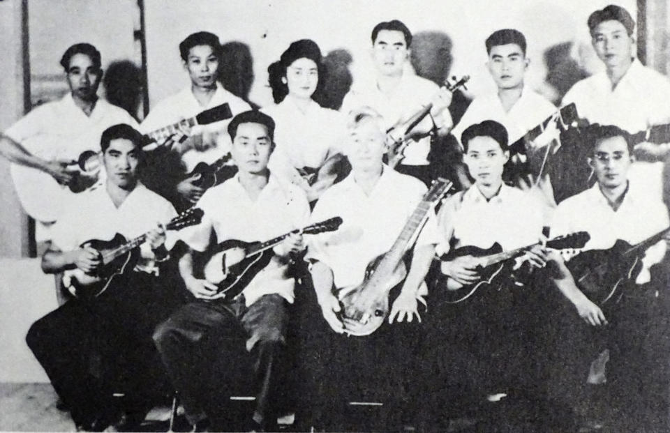 In this 1943 photo provided by Hidekazu Tamura, Tamura, second from left in front row, poses with his Mandolin band at Gila River War Relocation Center at southeast of Phoenix during the pacific war period. Gila River War Relocation Center was one of 10 internment camps of American Japanese residents during the war. At 99, as the 75th anniversary of the formal Sept. 2 surrender ceremony that ended WWII approaches, Tamura, 99, has vivid memories of the wartime years he spent in the United States, torn between two nationalities, and the events that led him to renounce his American citizenship and return to Japan. (Courtesy of Hidekazu Tamura via AP)