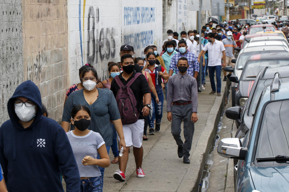 Los votantes hacen fila afuera de una mesa de sufragios durante las elecciones presidenciales y legislativas en Guayaquil, Ecuador, el domingo 7 de febrero de 2021. (Foto AP/Angel Dejesus)