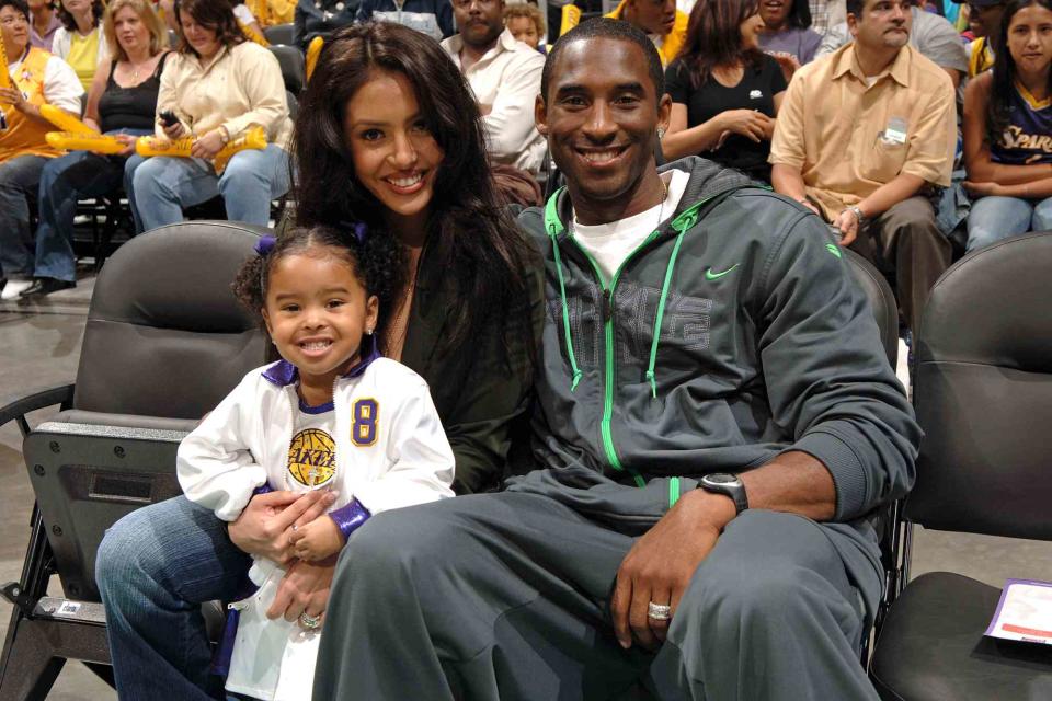 <p>Andrew D. Bernstein/NBAE via Getty</p> Kobe Bryant with his wife Vanessa and child Natalia watch the Los Angeles Sparks play the Sacramento Monarchs on August 16, 2005 