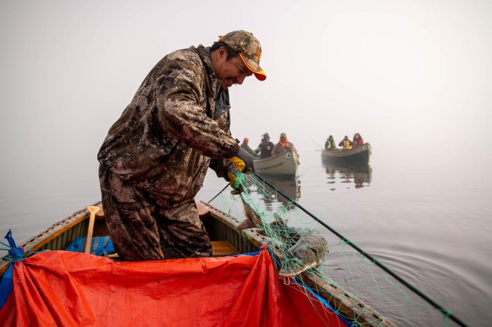 On a foggy morning, Neskantaga First Nation community members take their cedar canoes to check the fishing nets for sturgeon.