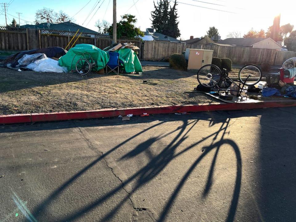 Homeless people store their possessions behind a retail center on Hatch Road in Ceres, Calif., Friday, Dec. 22, 2023.