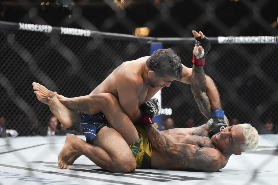 Charles Oliveira, bottom right, and Beneil Dariush fight during a lightweight bout at UFC 289 in Vancouver, British Columbia on Saturday, June 10, 2023. (Darryl Dyck/The Canadian Press via AP)