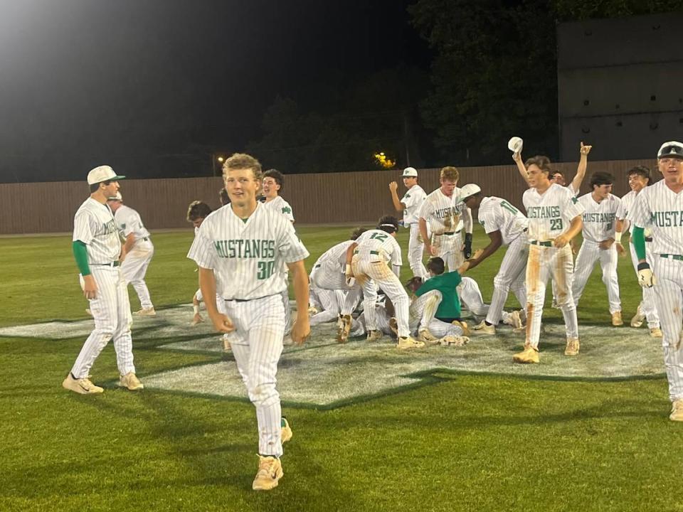 The Myers Park Mustangs celebrate on their home field after scoring six runs in the final two innings to win the conference title.