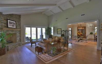 <p>The living room has high, beamed ceilings, french doors and a large, stone fireplace. (Trulia.com) </p>