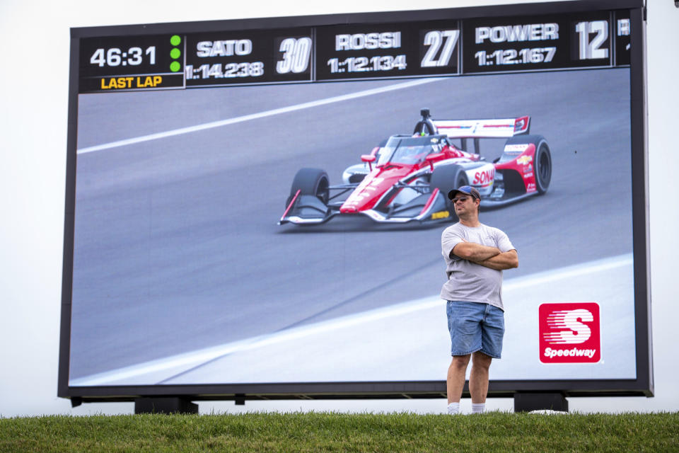 A fan watches the action on the track during a practice session for the IndyCar auto race at Indianapolis Motor Speedway, Friday, Aug. 13, 2021, in Indianapolis. (AP Photo/Doug McSchooler)