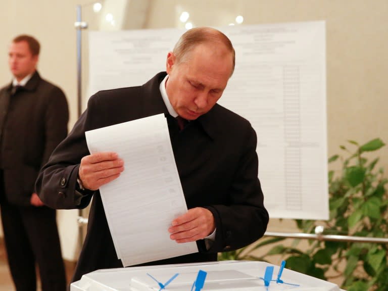 Russian President Vladimir Putin casts ballots as he votes at a polling station during parliamentary elections in Moscow