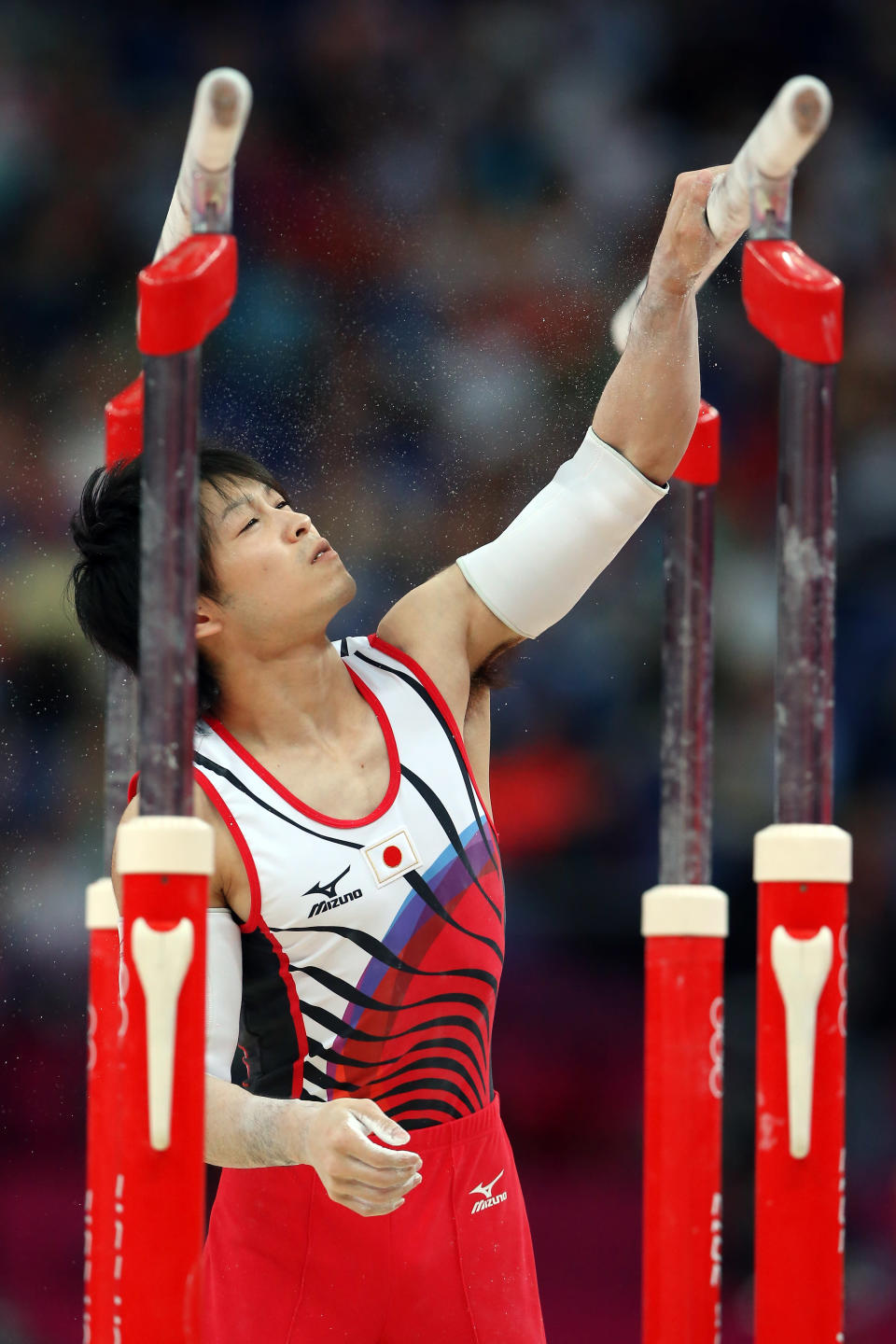 LONDON, ENGLAND - JULY 30: Kohei Uchimura of Japan puts chalk on the parallel bars in the Artistic Gymnastics Men's Team final on Day 3 of the London 2012 Olympic Games at North Greenwich Arena on July 30, 2012 in London, England. (Photo by Streeter Lecka/Getty Images)