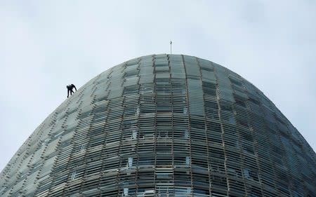 French climber Alain Robert, also known as "The French Spiderman", scales the 38-story skyscraper Torre Agbar in Barcelona, Spain, November 25, 2016. REUTERS/Albert Gea