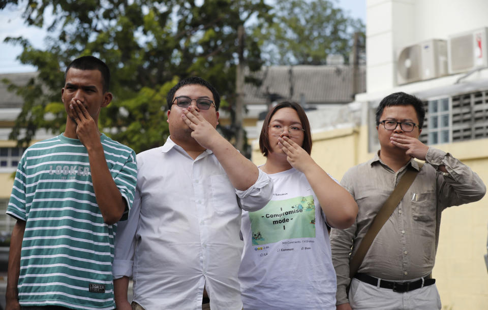 Pro-democracy activists, from left, Panupong Jadnok, Parit Chiwarak, Panusaya Sithijirawattanakul, and Arnon Nampha raise a three-fingers salute, a symbol of resistance at Chana SongKhram police station in Bangkok, Thailand Monday, Nov. 30, 2020. The leaders of the pro-democracy protests reported themselves to the police for the additional charge of violating the lese majeste laws at Chanasongkram Police Station on Monday afternoon. (AP Photo/Sakchai Lalit)