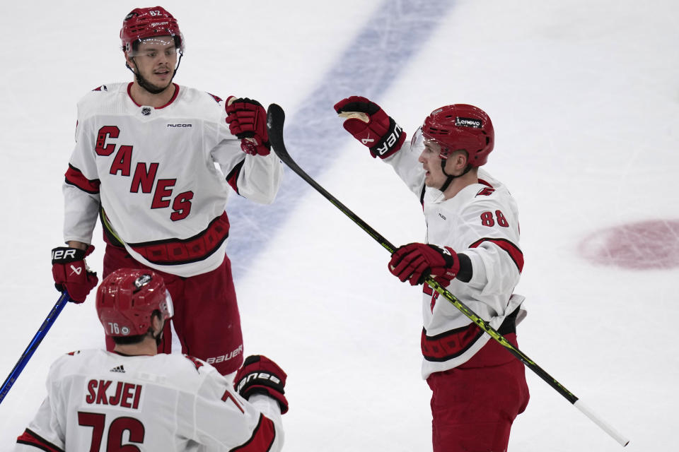 Carolina Hurricanes center Martin Necas, right, is congratulated by Brady Skjei (76) and Jesperi Kotkaniemi, top left, for his goal against the Boston Bruins during the first period of an NHL hockey game Wednesday, Jan. 24, 2024, in Boston. (AP Photo/Charles Krupa)