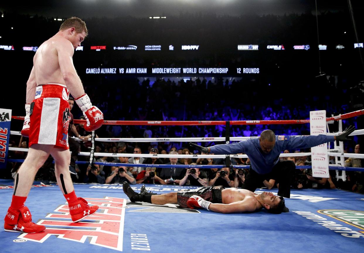 Canelo Álvarez, a la izquierda, observa tras noquear a Amir Khan en su combate de peso mediano de their WBC, el sábado 7 de mayo de 2016 en Las Vegas. (AP Foto/John Locher)