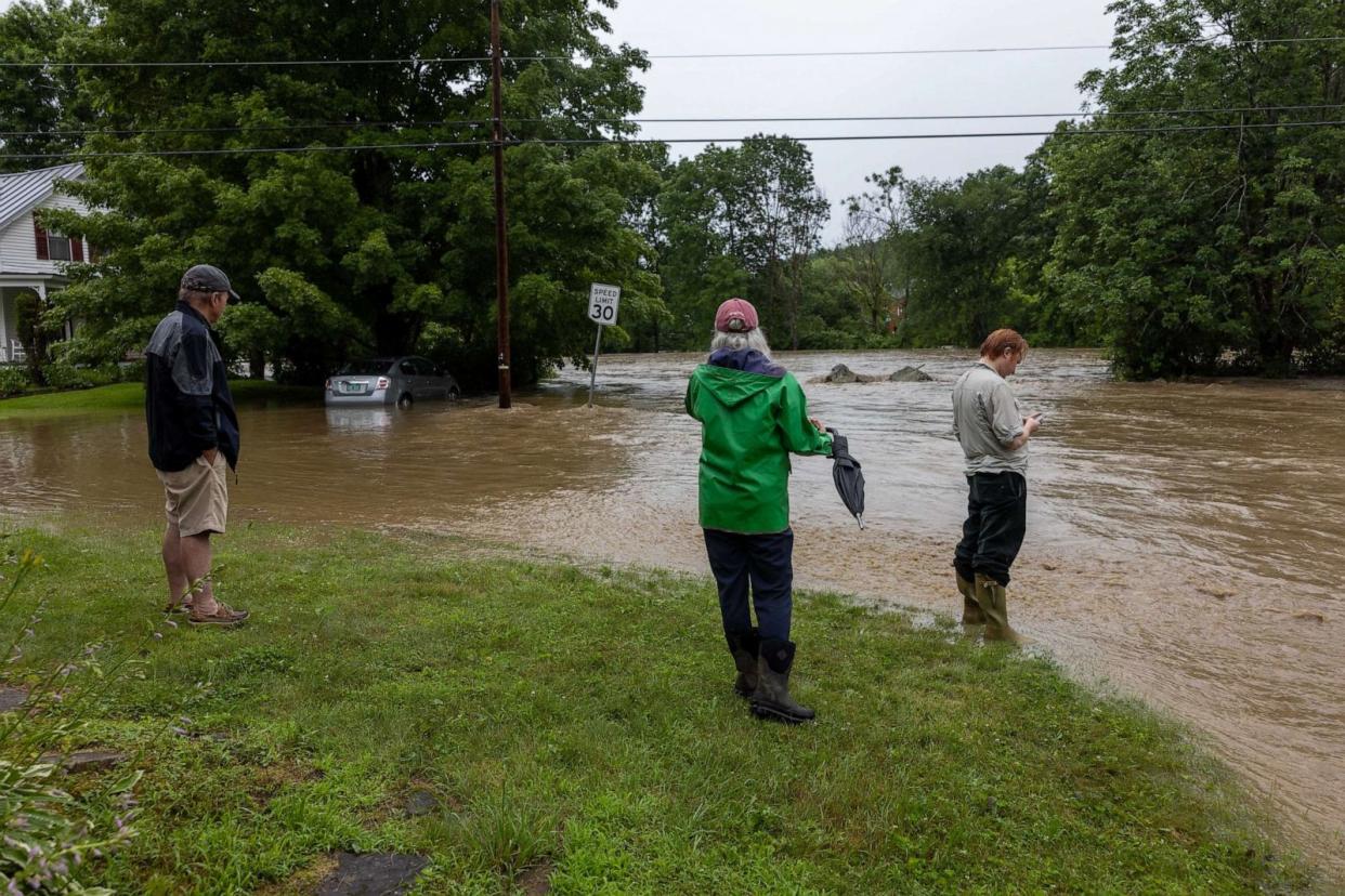 PHOTO: Onlookers check out a flooded road on July 10, 2023 in Chester, Vt. Torrential rain and flooding has affected millions of people from Vermont south to North Carolina. (Scott Eisen/Getty Images)