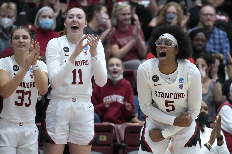 Stanford's Francesca Belibi (5), Ashten Prechtel (11) and Hannah Jump (33) cheers on teammates from the bench during the first half of a first-round game against Montana State in the NCAA women's college basketball tournament Friday, March 18, 2022, in Stanford, Calif. (AP Photo/Tony Avelar)