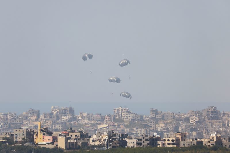 Ayuda humanitaria cae por el cielo hacia la Franja de Gaza, vista desde Israel