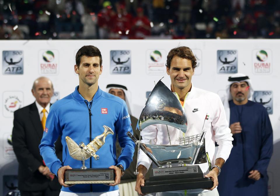 Roger Federer (R) of Switzerland and Novak Djokovic of Serbia pose with their first and second place trophies after their final match at the ATP Championships tennis tournament in Dubai February 28, 2015. REUTERS/Ahmed Jadallah (UNITED ARAB EMIRATES - Tags: SPORT TENNIS)