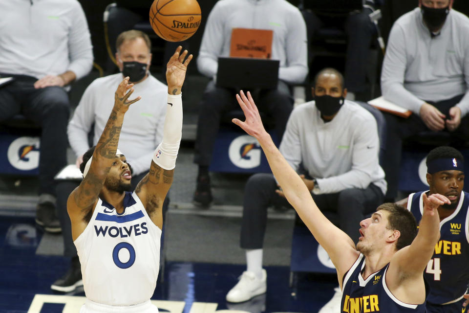 Minnesota Timberwolves guard D' Angelo Russell (0) shoots over Denver Nuggets center Nikola Jokic (15) in the first quarter during an NBA basketball game, Sunday, Jan. 3, 2021, in Minneapolis. (AP Photo/Andy Clayton-King)