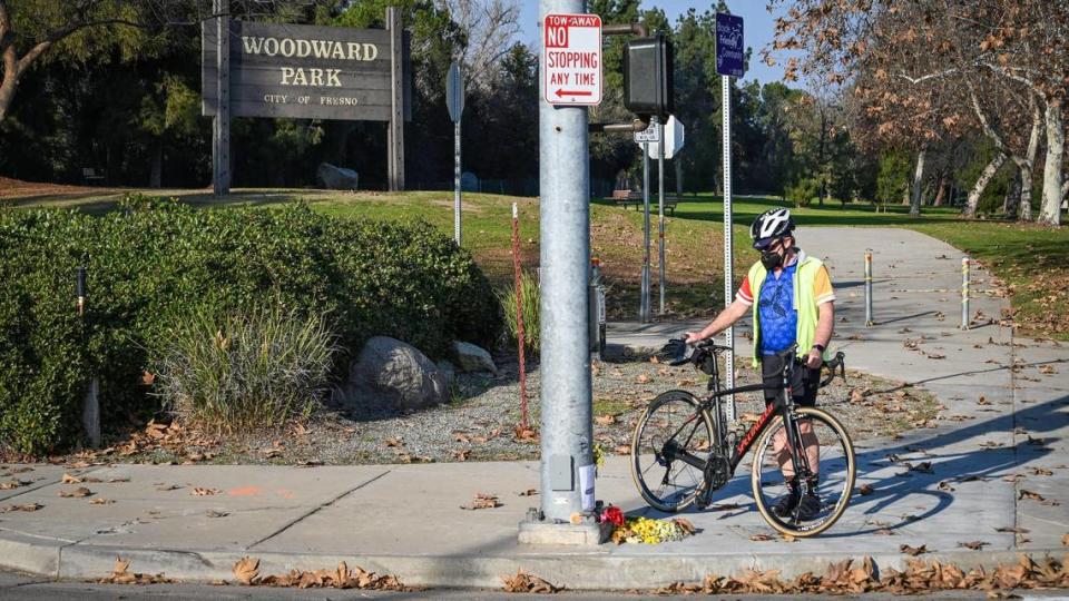 Tony Molina, a retired Fresno physician and cycling advocate who is chair of the Fresno County Cycling Coalition and a co-founder of the community advocacy group Safe Access to Woodward Park, stops by a small memorial for his friend Paul Moore at the corner of Friant Road and Audubon Drive on Wednesday, Jan. 19, 2022.