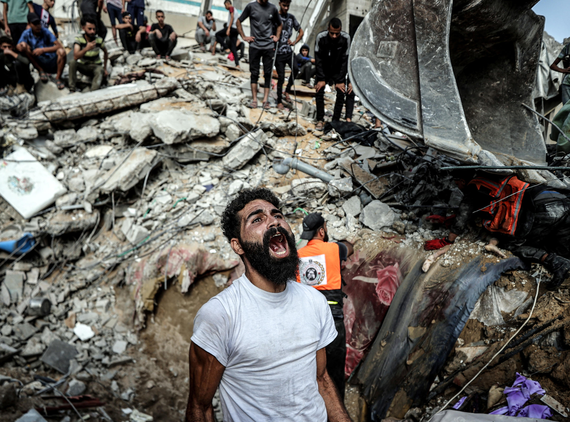 A man yells out as rescue teams search the debris of a building following an Israeli airstrike in Gaza City.