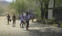 In this image made from video, an injured person is carried towards an ambulance in Mekele, Ethiopia, Wednesday, Oct. 20, 2021. Residents say new airstrikes have hit the capital of Ethiopia’s Tigray region as exclusive video shows injured people with bloodied faces being carried into ambulances. Ethiopia's government says it targeted facilities for making and repairing weapons, while a Tigray spokesman denies it. (AP Photo)