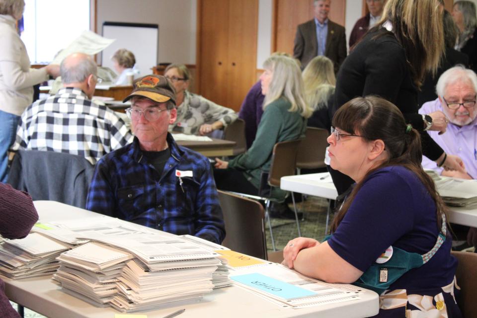 Recount watchers are seen at Charlevoix Township hall on Dec. 12. Challengers wore a red dot on their lapel and proponents wore a green dot.