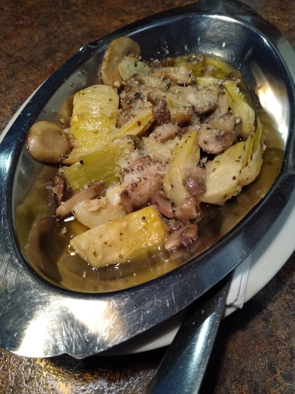 Casa D’Angelo’s artichoke appetizer features artichokes and mushrooms in a garlic wine sauce topped with a sprinkle of Parmesan cheese.