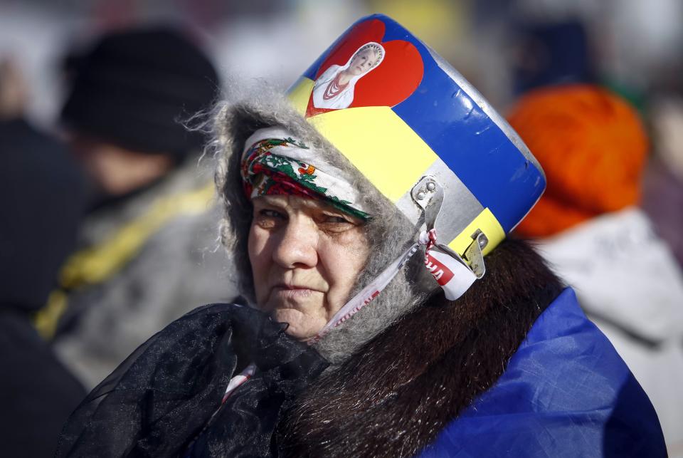 A supporter of anti-government protesters wears a pot decorated with national colors and a portrait of jailed opposition leader Yulia Tymoshenko in the camp at Independence Square in central Kiev