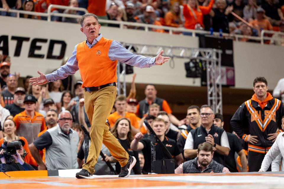 Oklahoma State coach John Smith reacts on the mat during Sunday's dual against Iowa at Gallagher Iba Arena in Stillwater.