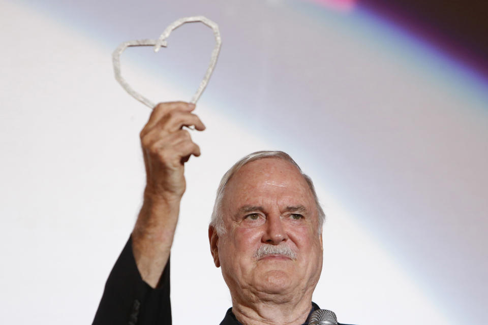 FILE - John Cleese poses for photos with Sarajevo Film Festival's top honour award, the Heart of Sarajevo Award, in Sarajevo, Bosnia, on Aug. 16, 2017. Cleese turns 82 on Oct. 27. (AP Photo/Amel Emric, File)