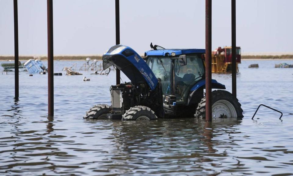 Farm machinery is seen at Hansen Ranches, an area flooded along 6th Avenue Tuesday afternoon, April 25, 2023 just south of Corcoran, CA.