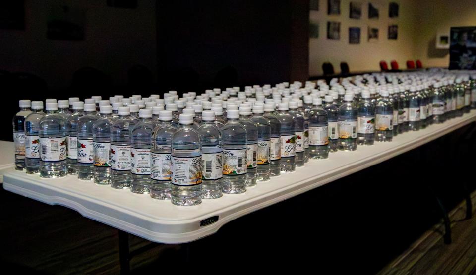 Bottled water lines tables at the AB Tech Conference Center as the site prepares to open as a shelter for displaced residents Saturday afternoon.