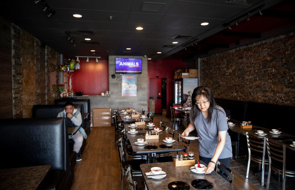 Debbie Chen arranges a table during the lunch hour at Shabu House, an Asian "comfort food'' restaurant in Houston on Saturday, February 15, 2020. Chen is one of the owners of Shabu House. The restaurant has seen business drop dramatically in the wake of the coronavirus outbreak.