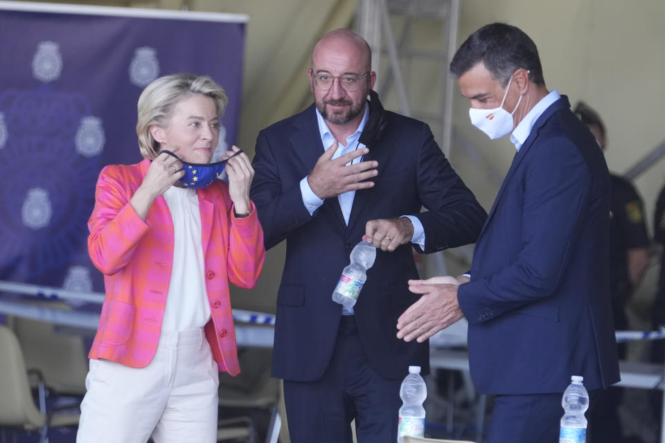 EU Commission president Ursula von der Leyen, left, EU Council President Charles Michel, center, and Spain's Prime Minister Pedro Sanchez prepare for a joint news conference at the Torrejon military airbase in Madrid, Spain, Saturday, Aug. 21, 2021. Top European Union officials visited a Spanish military airport being used as a hub to receive Afghans flown out of Kabul before they are distributed to other countries in the bloc. (AP Photo/Paul White)