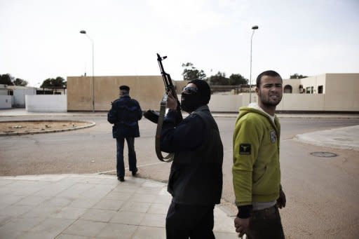 Libyan rebel fighters patrol the streets of the eastern key Libyan oil town of Ras Lanuf where troops stormed into as tanks outflanked rebels holding the key oil town, forcing them to retreat east under a hail of rocket fire