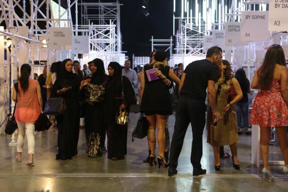 In this Thursday, Oct. 17, 2013 photo, Emirati and foreign visitors take part in the Fashion Forward show in Dubai, United Arab Emirates. Dubai and luxury are nearly synonymous. The city is home to the world’s tallest tower, massive manmade islands in the shape of palm trees and a fleet of police cars that include a Ferrari, Lamborghini and a $2.5 million Bugatti Veyron. To boost its glamour factor and economy, the city has its eyes set on the multi-billion dollar a year global fashion industry, which is currently dominated by the U.S., Europe and Japan. (AP Photo/Kamran Jebreili)