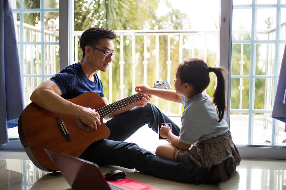 Dad playing guitar for child