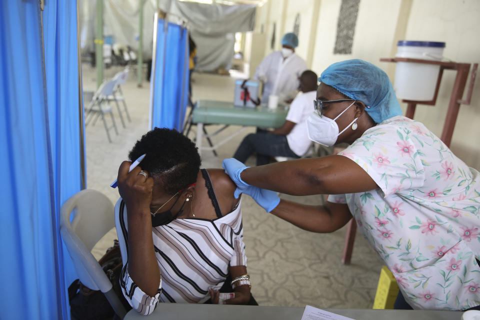 FILE - In this Tuesday, July 27, 2021 file photo, a health worker injects a person with a dose of the Moderna vaccine for COVID-19 at Saint Damien Hospital in Port-au-Prince, Haiti. In late June, the international system for sharing coronavirus vaccines sent about 530,000 doses to Britain – more than double the amount sent that month to the entire continent of Africa. It was the latest example of how a system that was supposed to guarantee low and middle-income countries vaccines is failing, leaving them at the mercy of haphazard donations from rich countries. (AP Photo/Joseph Odelyn, file)